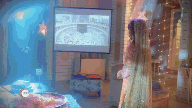 a woman standing in front of a projector screen that says zee on it