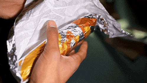 a person holding a piece of aluminum foil