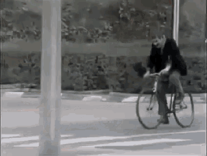a man is riding a bike on a street in a black and white photo .