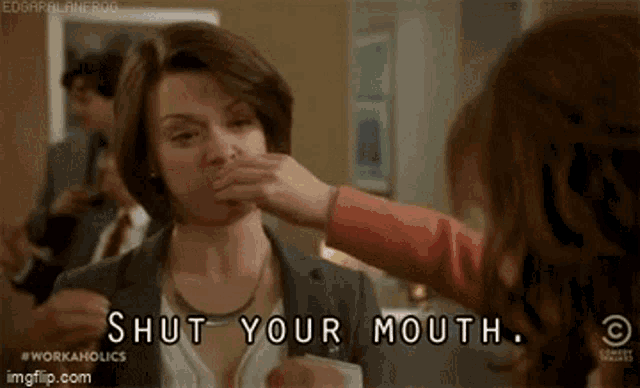 a woman is covering her mouth with a napkin while another woman says `` shut your mouth '' .