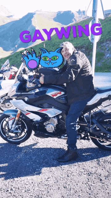 a man standing next to a motorcycle with the word gaywing written on it