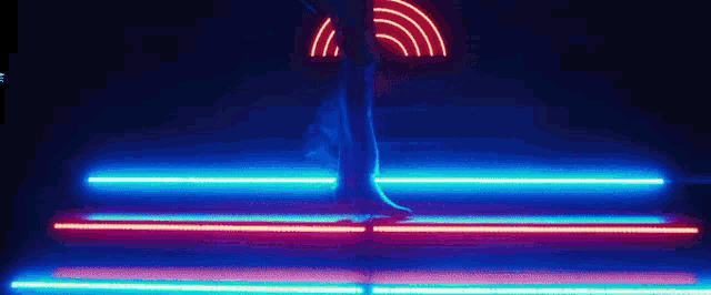 a person is walking down a set of stairs with neon lights behind them .