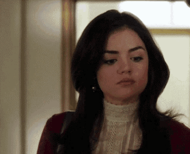 a woman with long dark hair is wearing a red jacket and a white blouse