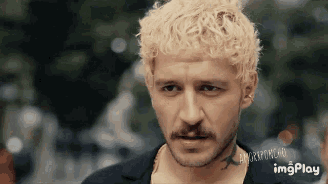 a man with blonde hair and a mustache has a tattoo on his neck that says imgplay