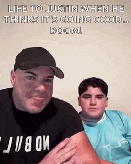 a man and a boy are sitting next to each other and the man is holding the boy 's arm .