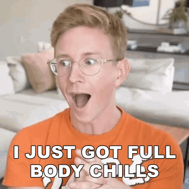 a man wearing glasses and an orange shirt says i just got full body chills