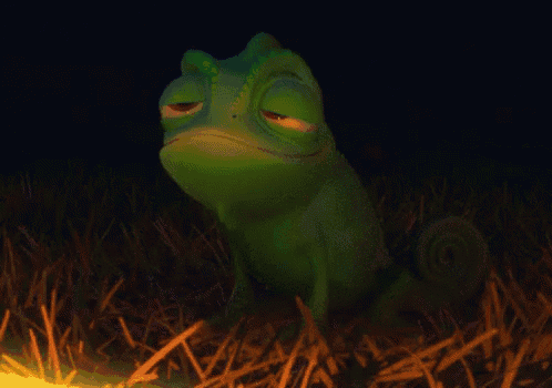 a green lizard with its eyes closed sitting in the grass