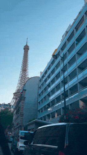 the eiffel tower is visible behind a building with balconies