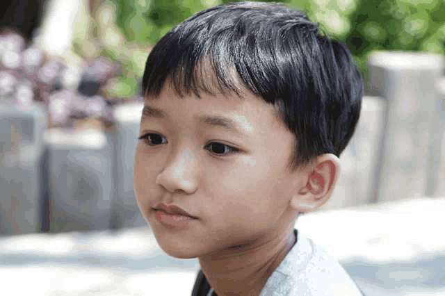 a close up of a young boy 's face with his eyes closed
