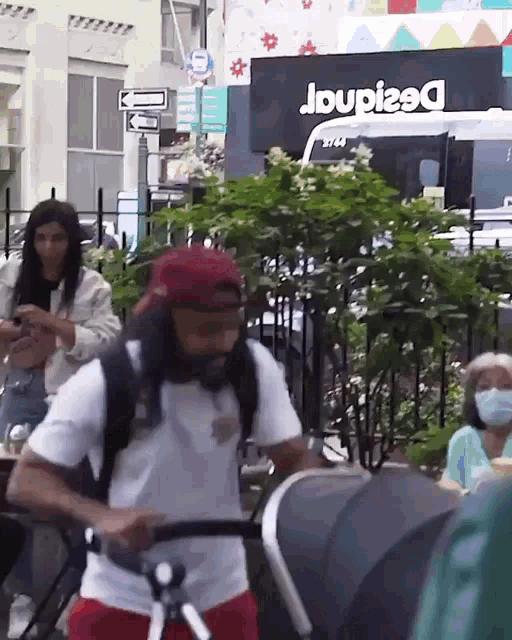 a man is pushing a stroller in front of a store called desigual