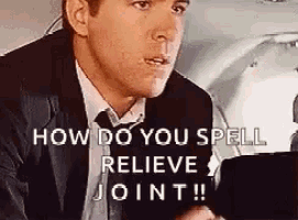 a man in a suit and tie is talking on a cell phone and says `` how do you spell relieve joint '' .