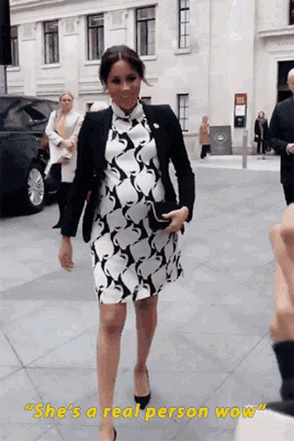 a woman in a black and white dress with the words " she 's a real person wow " on the bottom