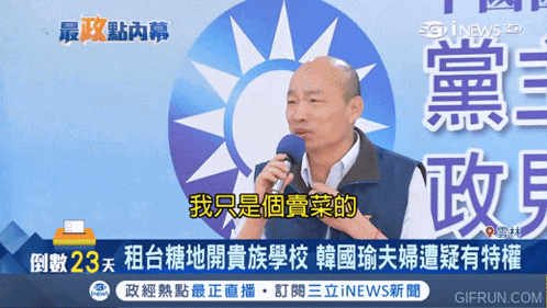a man speaking into a microphone in front of a blue and white sun
