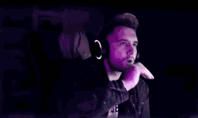 a man is smoking a cigarette while wearing headphones .