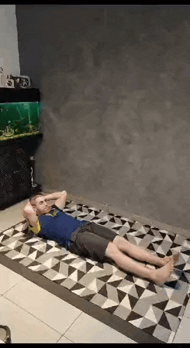 a man is laying on a rug doing sit ups in a living room .