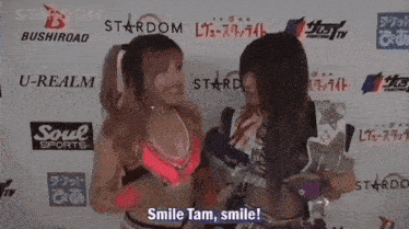 two women are standing in front of a wall that says stardom and u-realm