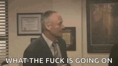a man in a suit and tie is talking to another man in a room and says `` what the fuck is going on '' .