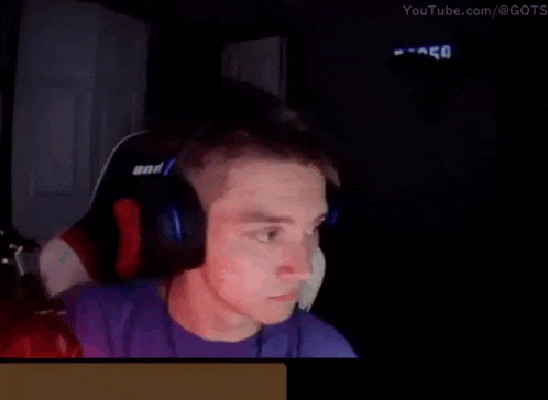 a man wearing headphones is sitting in front of a computer screen .
