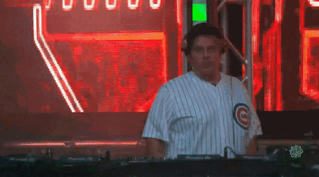 a man wearing a chicago cubs jersey is playing a dj set