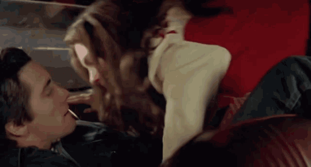 a man and a woman are kissing in the back of a car .