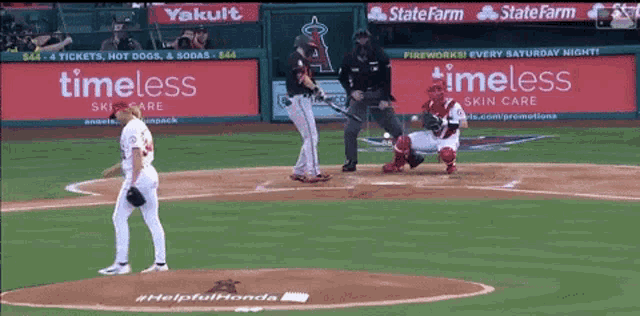 a baseball game is being played in front of a timeless skin care sign