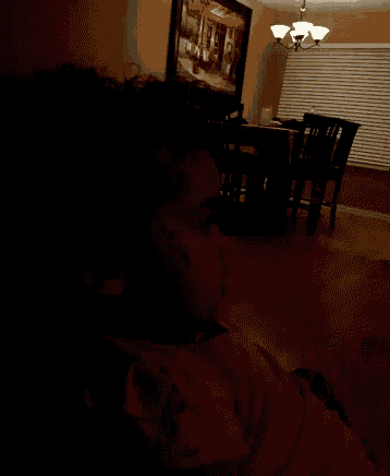 a person laying in a dark room with a picture of an umbrella on the wall