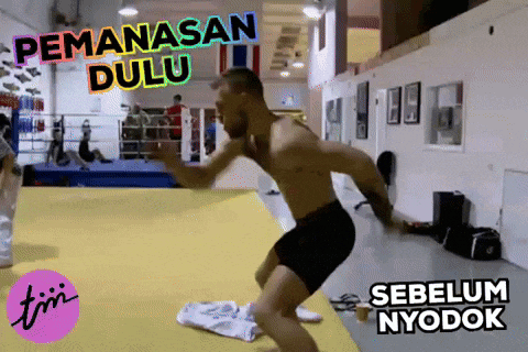 a man is jumping in the air in a boxing ring with the words pemanasan dulu below him