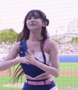 a cheerleader is dancing on a baseball field in front of a crowd .