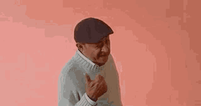 a man wearing a hat and a sweater is giving a middle finger .