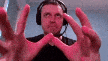 a man wearing headphones is making a cross with his hands in front of him .