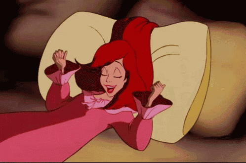 a cartoon woman with red hair is laying on a pillow