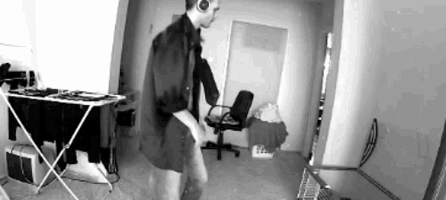 a black and white photo of a man wearing headphones dancing