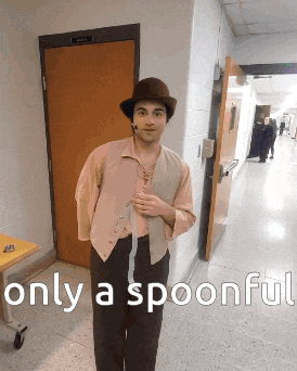 a man in a hat is standing in a hallway with only a spoonful written below him