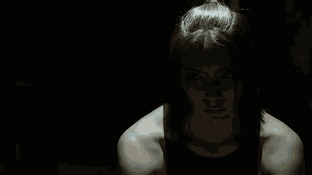 a woman with red paint on her face looks down at something