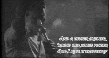 a black and white photo of a man singing into a microphone