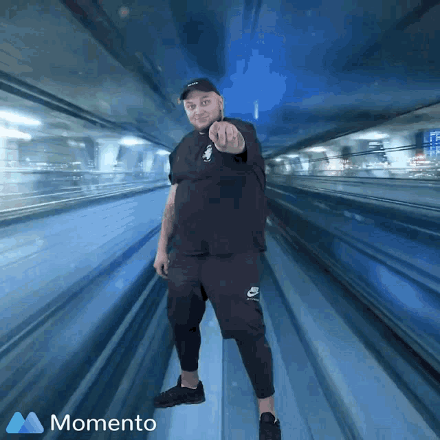 a man is pointing at the camera while wearing a nike shirt