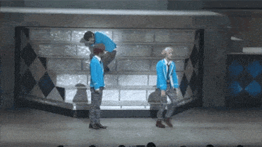 a group of people are standing on a stage in front of a brick wall .