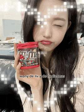 a woman is holding a can of m & m 's in her hand .
