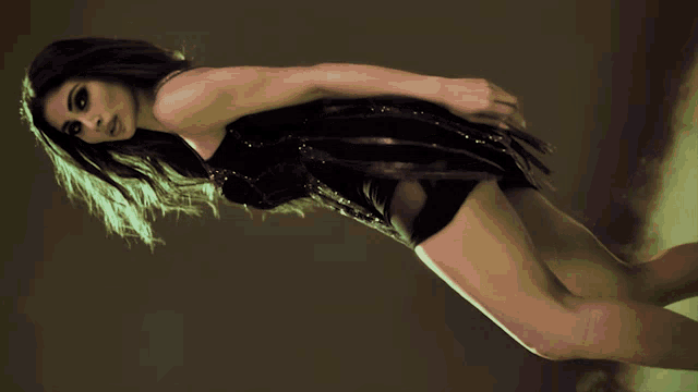 a woman in a black dress is laying on her stomach