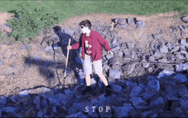 a person standing on a pile of rocks with the word stop written in the corner