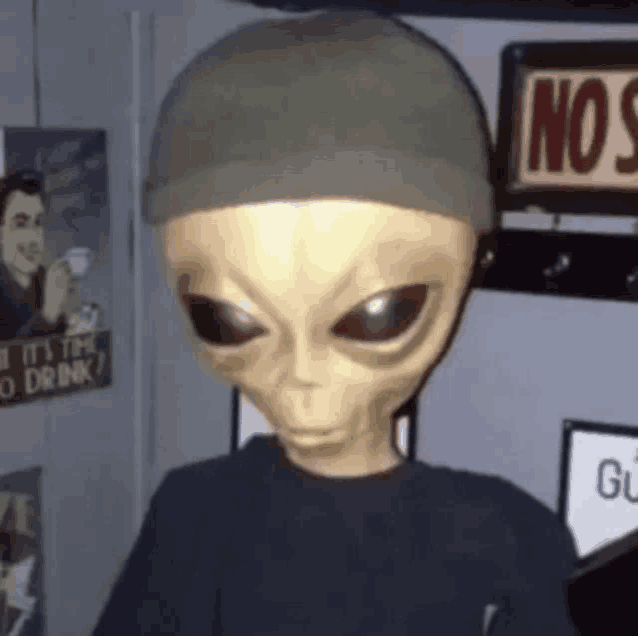 a statue of an alien wearing a hat and a t-shirt
