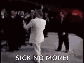 a man in a white suit is dancing on a stage in front of a crowd of people .