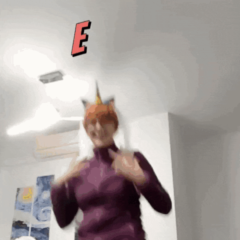 a woman wearing a cat hat is dancing in front of a ceiling with the letter e on it