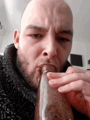 a man with a beard drinking from a bottle