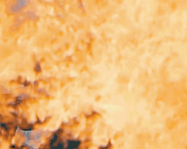 a man in a grey shirt is surrounded by flames coming out of his shirt