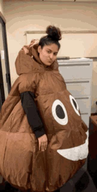 a woman in a poop costume is standing in front of a cabinet