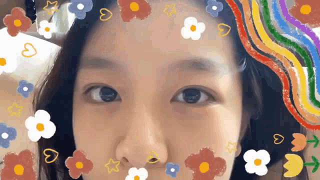 a close up of a woman 's face with flowers and hearts around her