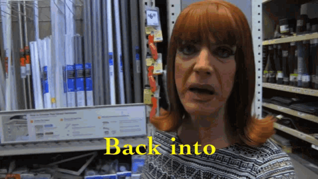 a woman with red hair is standing in front of a sign that says " back into "