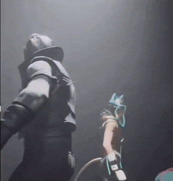 a man and a woman are standing in a dark room in a video game .
