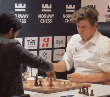 two men are playing chess in front of a norway chess sign